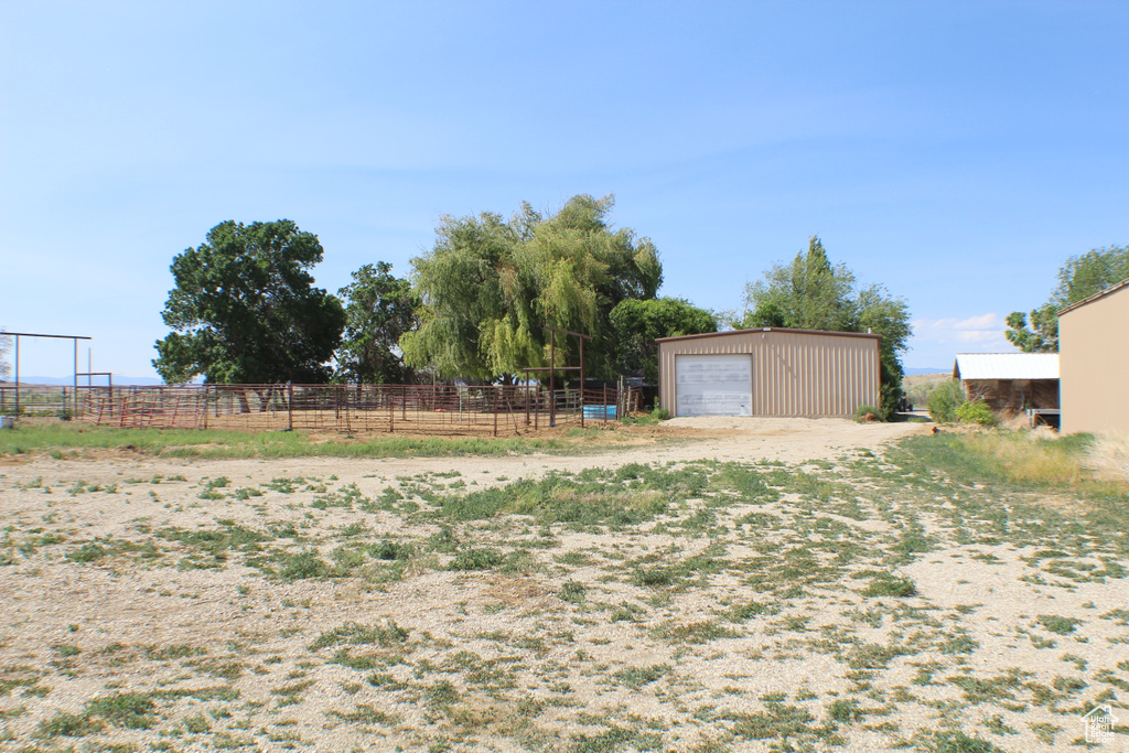 View of yard featuring an outbuilding, a garage, and a view of rural / pastoral area