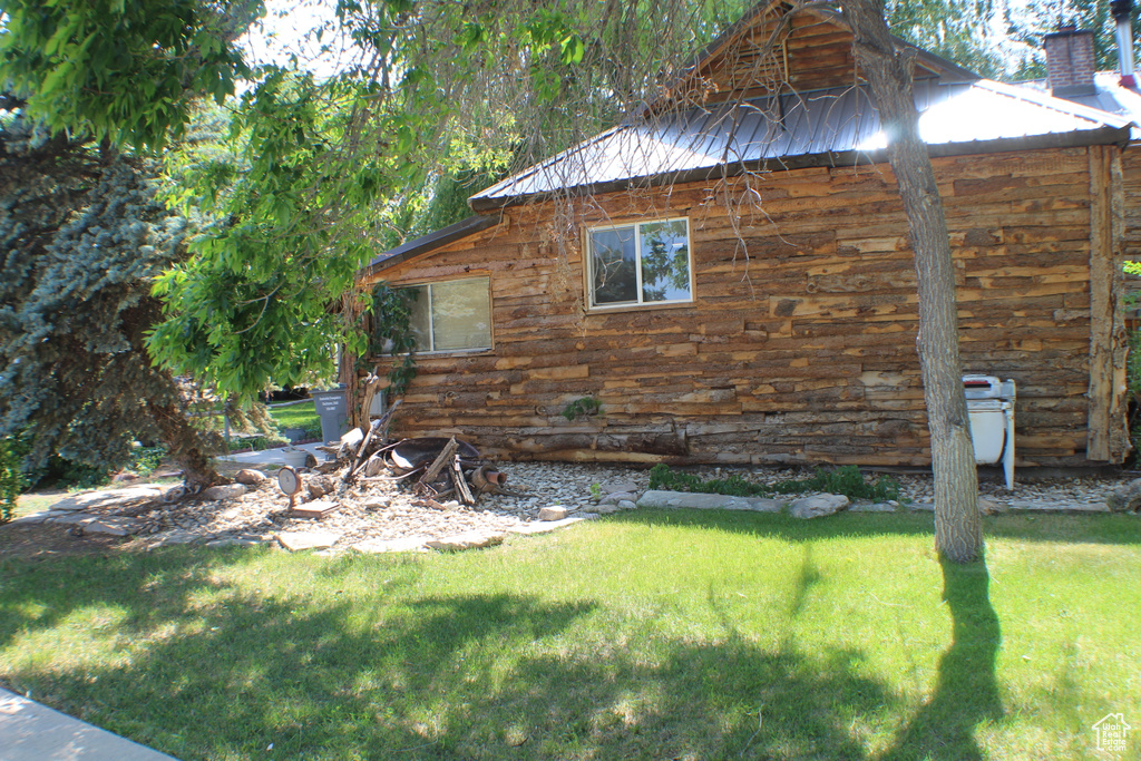 View of home\'s exterior featuring a yard and log exterior