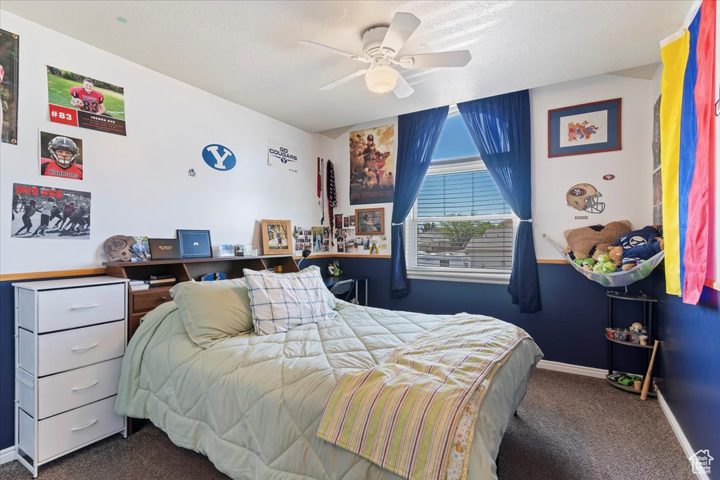 Carpeted bedroom with baseboards and a ceiling fan