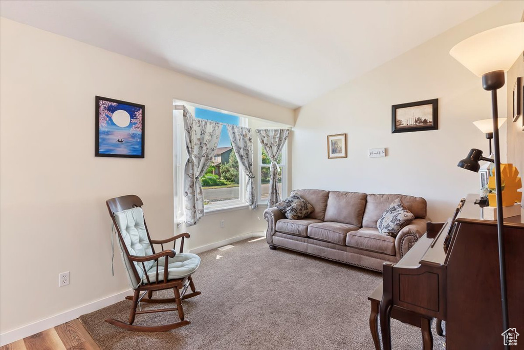 Living room with baseboards and lofted ceiling