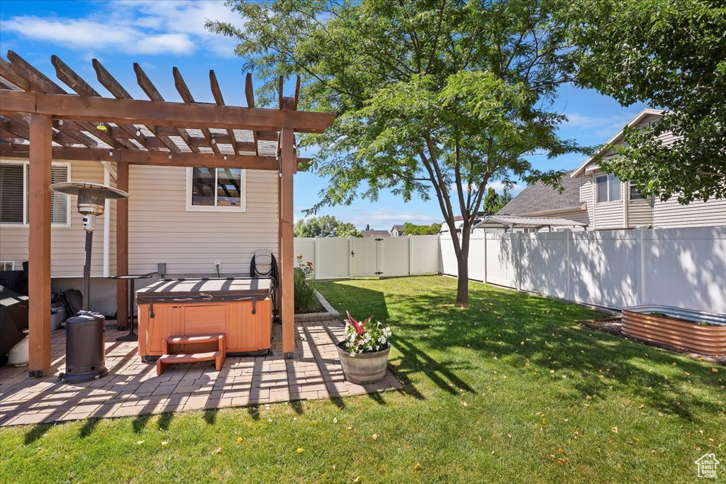 View of yard featuring a hot tub, a patio area, and a pergola