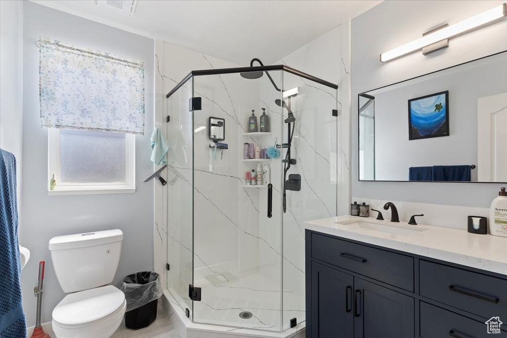 Full bath featuring vanity, a stall shower, and toilet