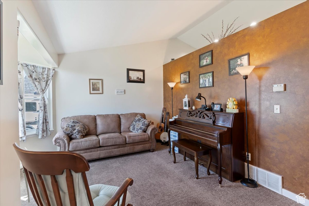 Living room featuring vaulted ceiling, carpet, and baseboards