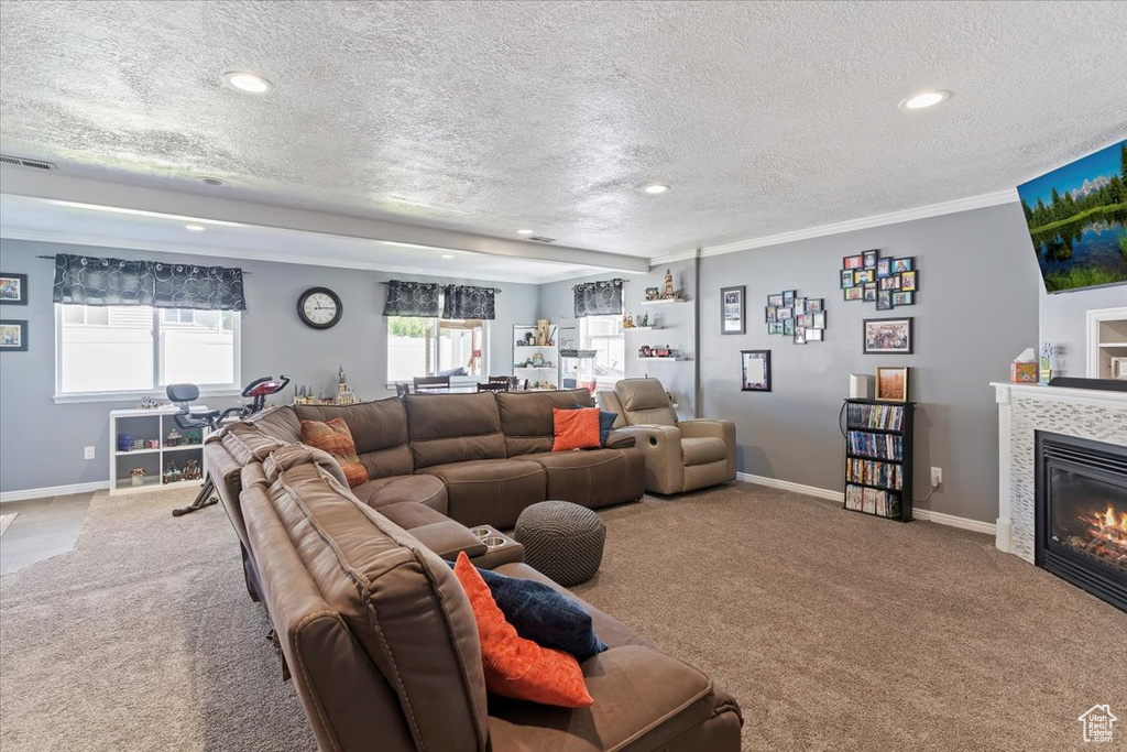 Living room featuring carpet flooring, a textured ceiling, recessed lighting, a fireplace, and baseboards