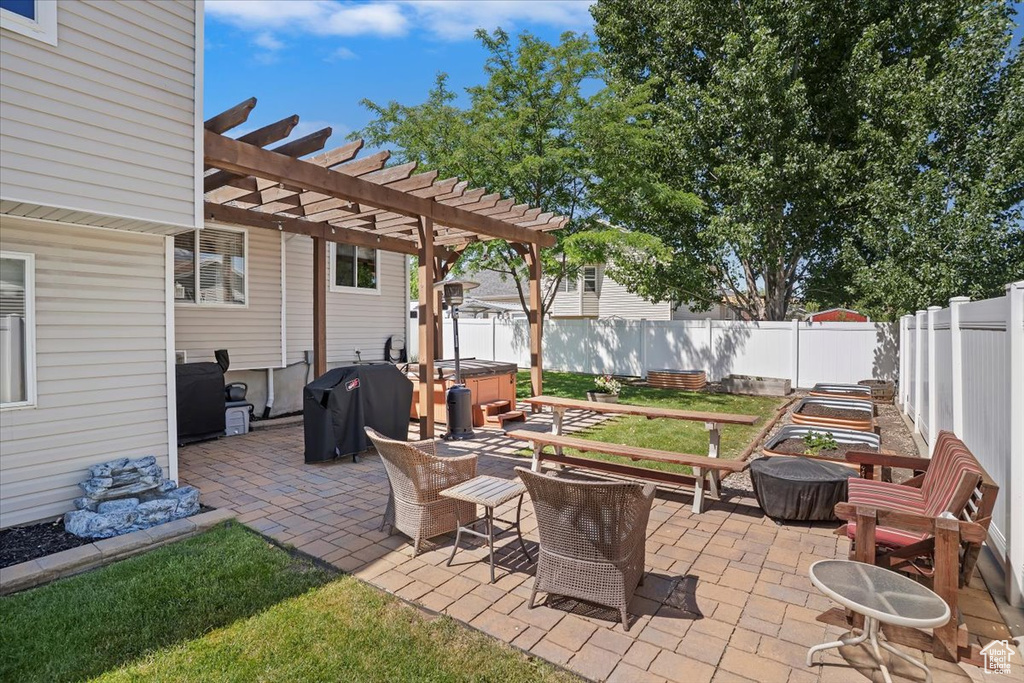 Fenced backyard with a hot tub, area for grilling, a patio, and a pergola