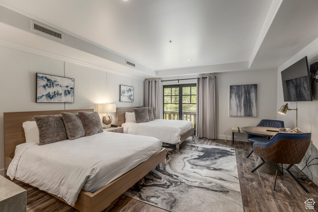 Bedroom with wood finished floors and a raised ceiling