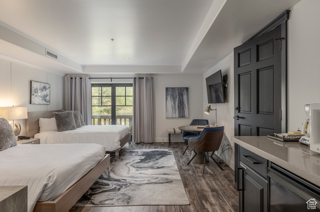 Bedroom with dark wood-type flooring and a raised ceiling