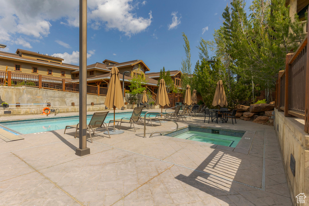 Community pool featuring a patio area and a hot tub