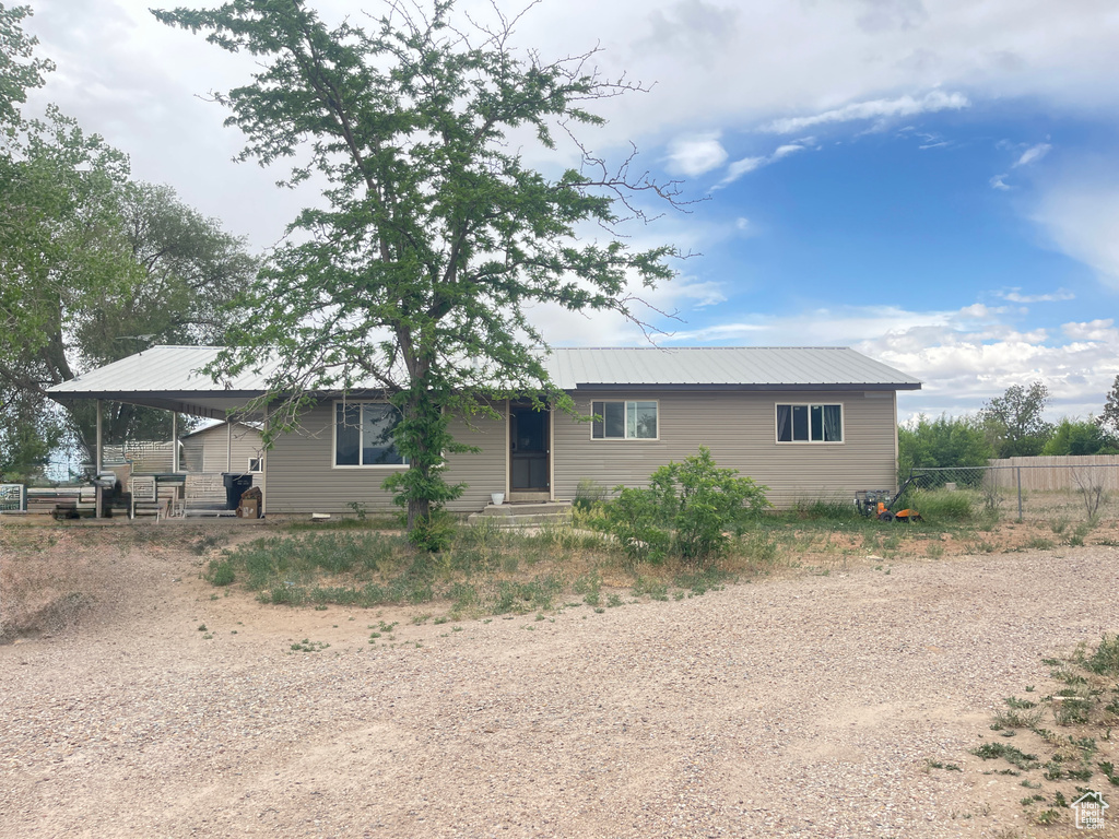 View of front facade featuring dirt driveway and metal roof