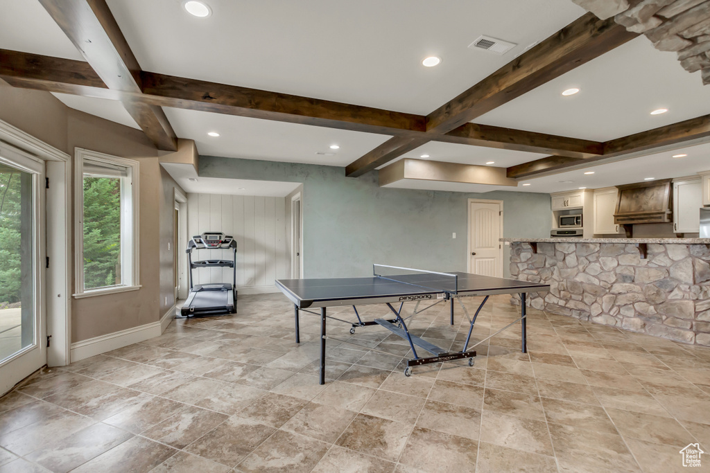 Rec room featuring beamed ceiling, baseboards, recessed lighting, and light stone finish flooring