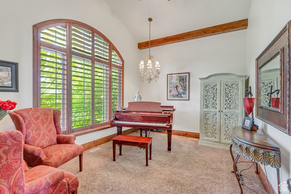 Sitting room featuring carpet, plenty of natural light, a chandelier, baseboards, and high vaulted ceiling