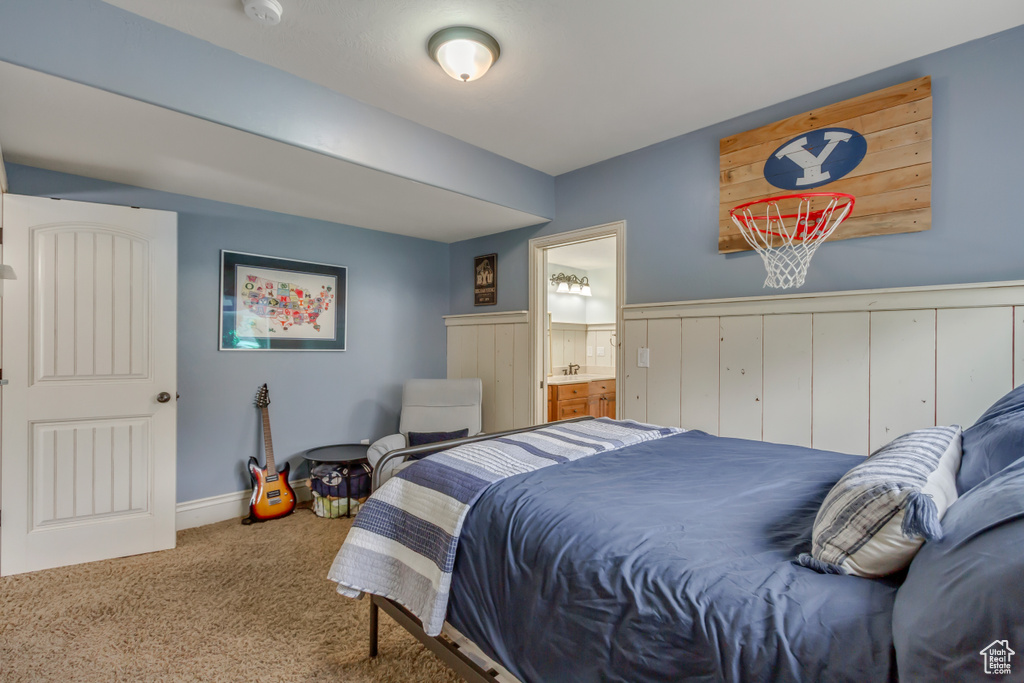 Carpeted bedroom with connected bathroom and baseboards