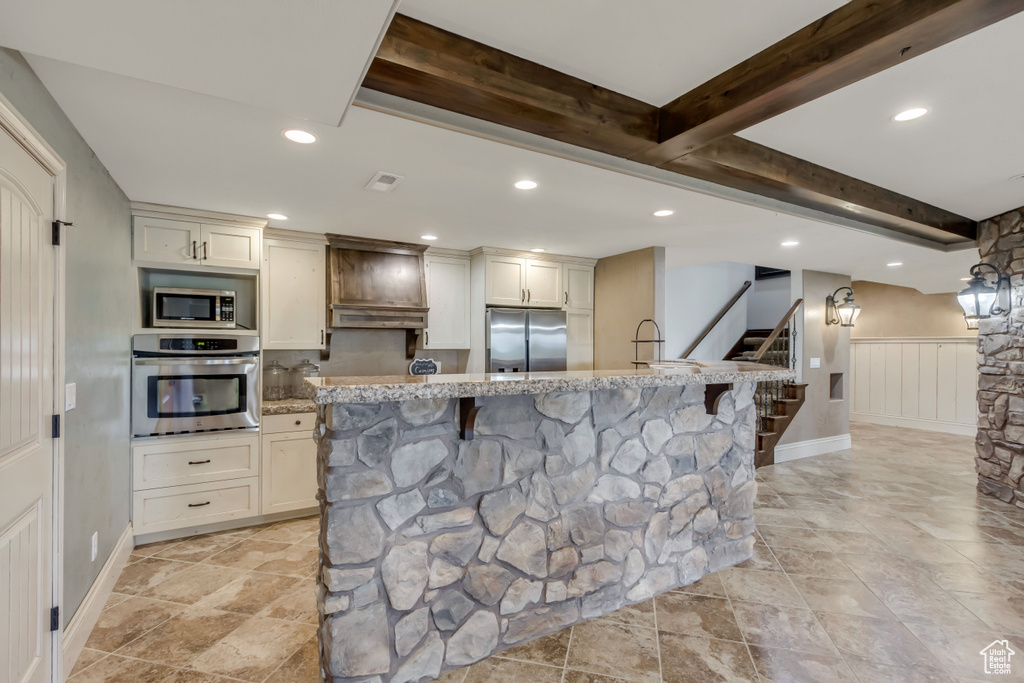 Kitchen with stainless steel appliances, recessed lighting, light stone countertops, a breakfast bar, and stone tile flooring