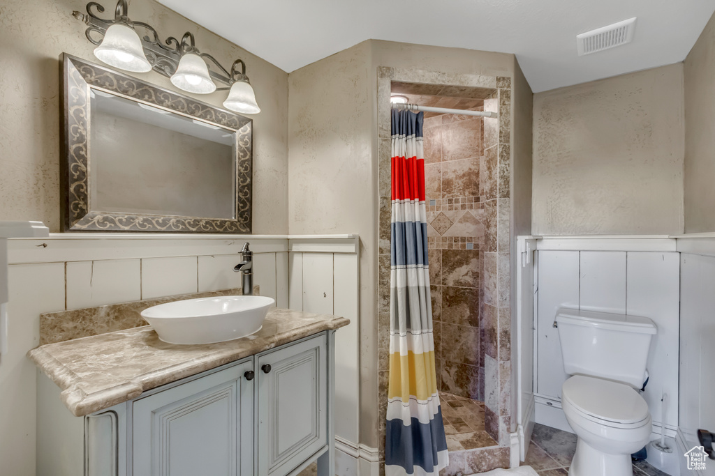 Full bath with vanity, toilet, and a shower stall