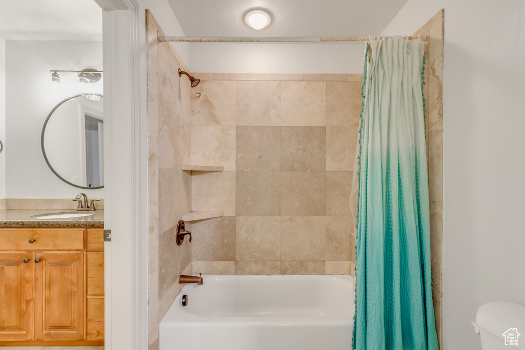 Full bathroom featuring shower / bath combo, vanity, and toilet