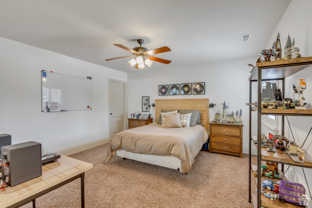 Bedroom featuring light carpet, baseboards, and a ceiling fan