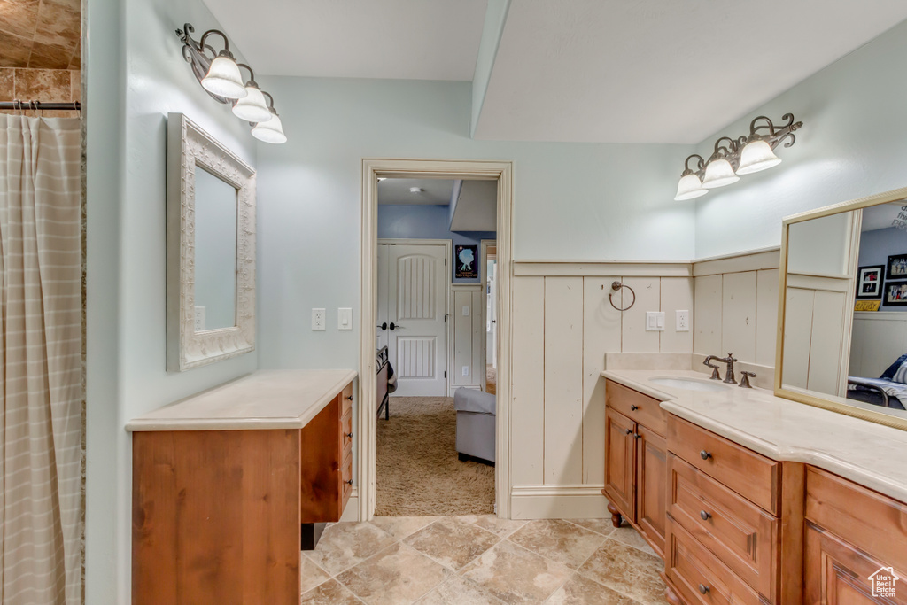 Bathroom featuring vanity, wainscoting, ensuite bath, and a shower with shower curtain