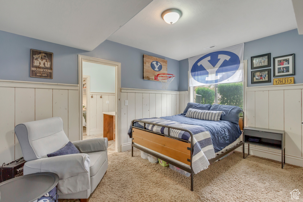 Bedroom with wainscoting and carpet floors