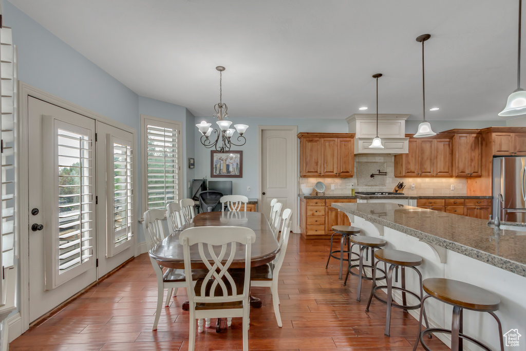 Dining room featuring a chandelier, wood finished floors, and recessed lighting