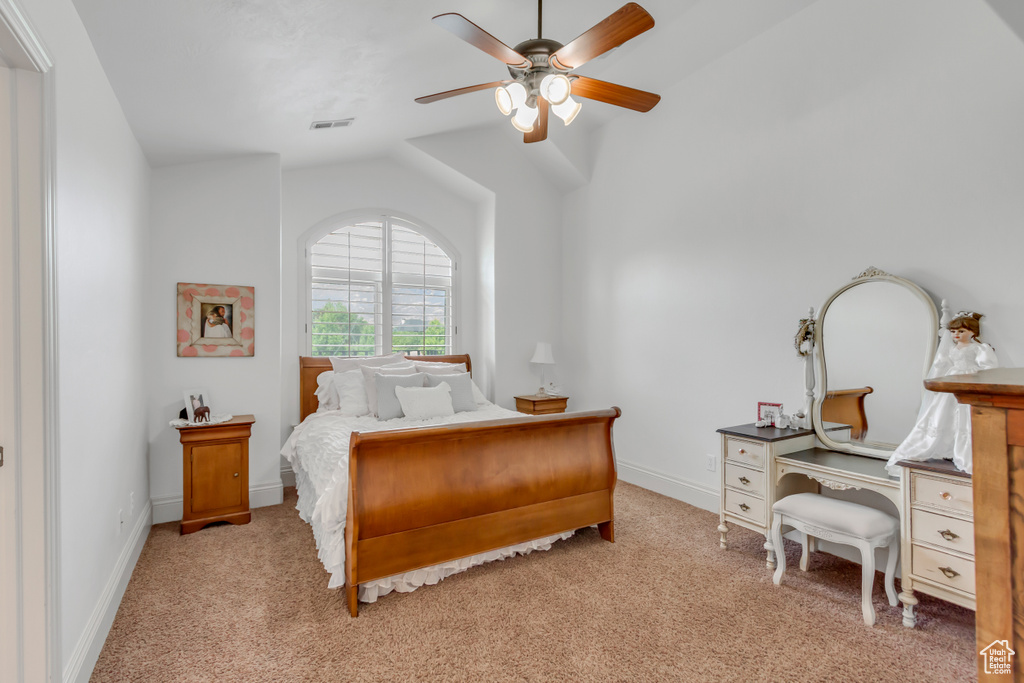 Bedroom featuring light colored carpet, vaulted ceiling, baseboards, and a ceiling fan