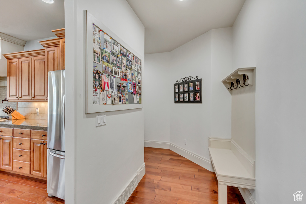 Mudroom with light wood-type flooring and baseboards
