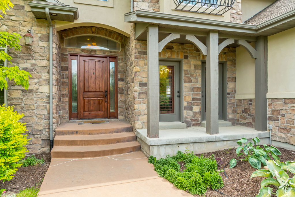 View of exterior entry featuring stucco siding and stone siding