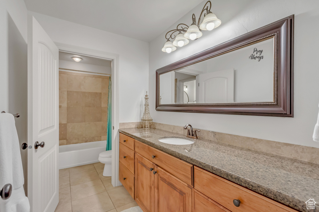 Bathroom with toilet, vanity, tile patterned floors, and shower / bath combination with curtain