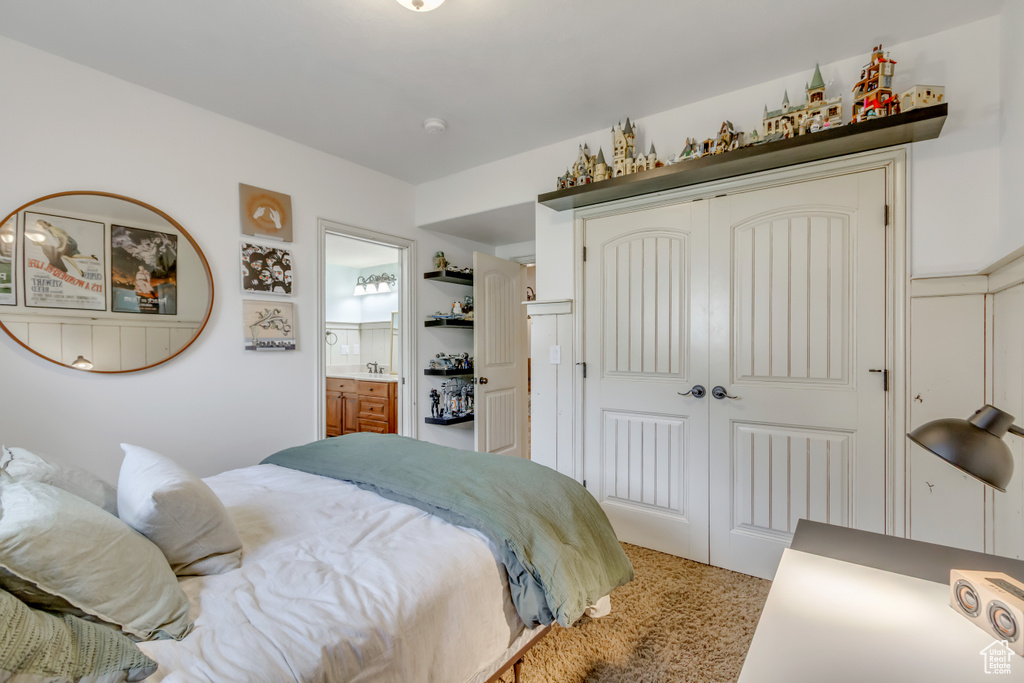 Bedroom with a closet, light carpet, and connected bathroom