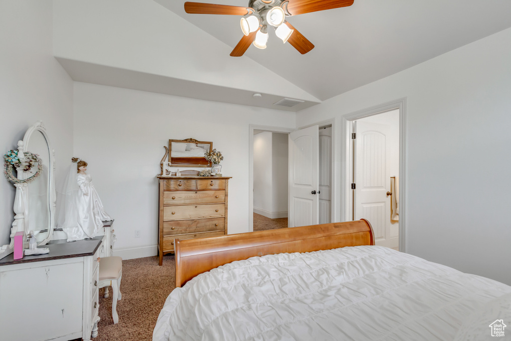 Carpeted bedroom featuring lofted ceiling, a ceiling fan, and baseboards