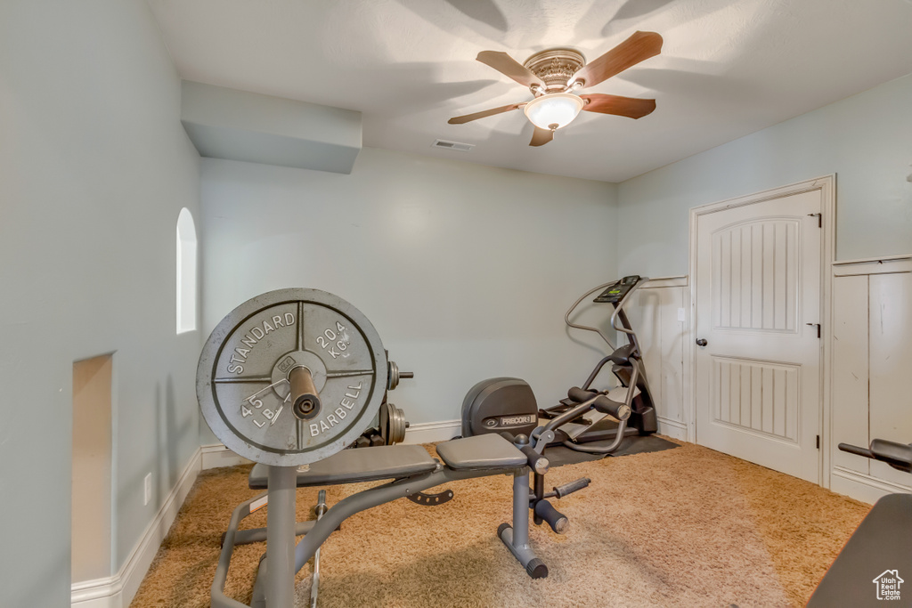 Workout area featuring a ceiling fan, carpet flooring, and baseboards