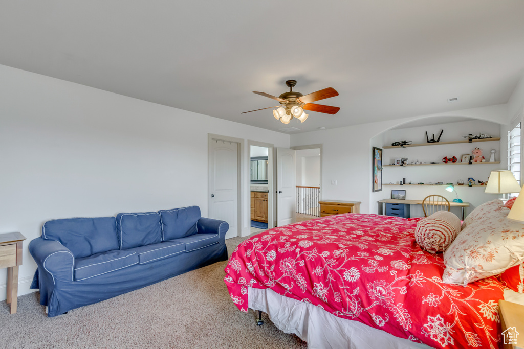 Bedroom featuring carpet floors, a ceiling fan, and connected bathroom