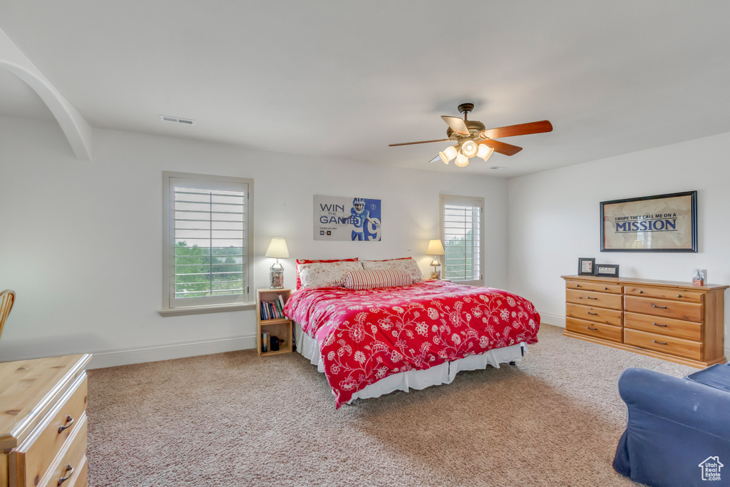 Bedroom with carpet floors, ceiling fan, and baseboards