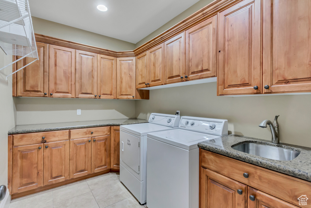 Laundry area with cabinet space, washer and clothes dryer, and light tile patterned flooring