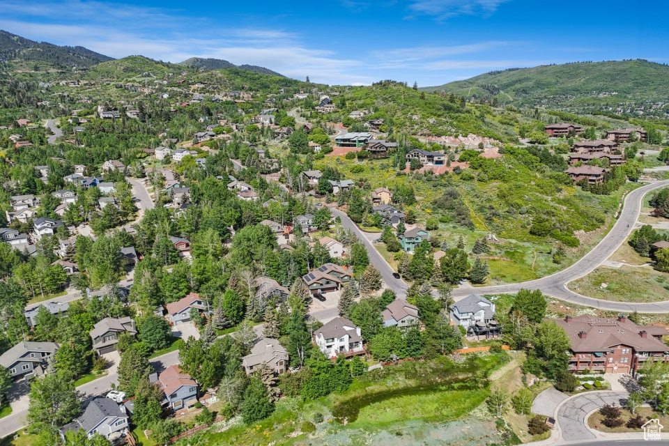 Aerial overview of property's location featuring nearby suburban area and a mountainous background