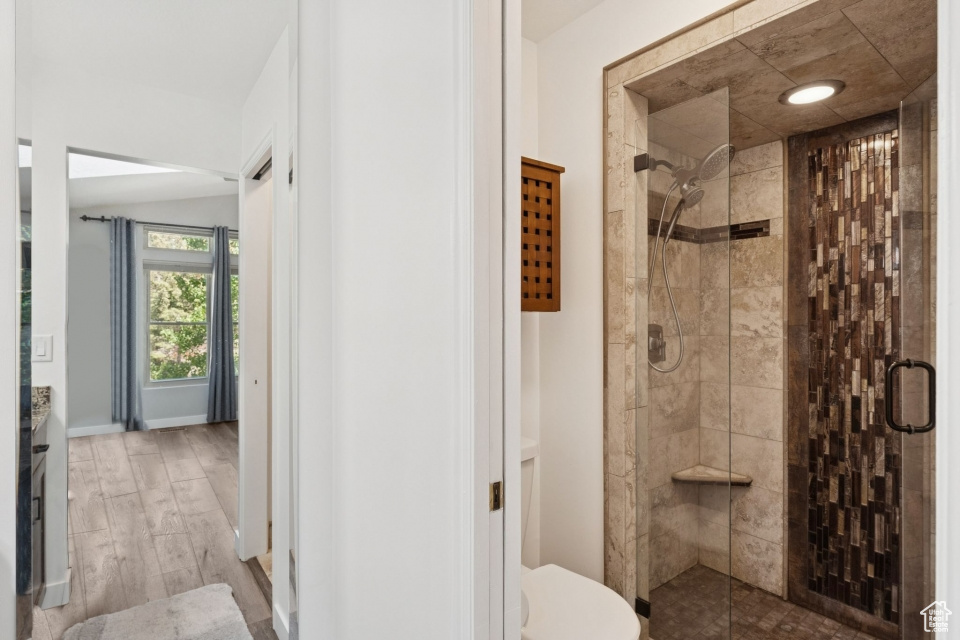 Bathroom with a shower stall, vanity, toilet, and wood finished floors