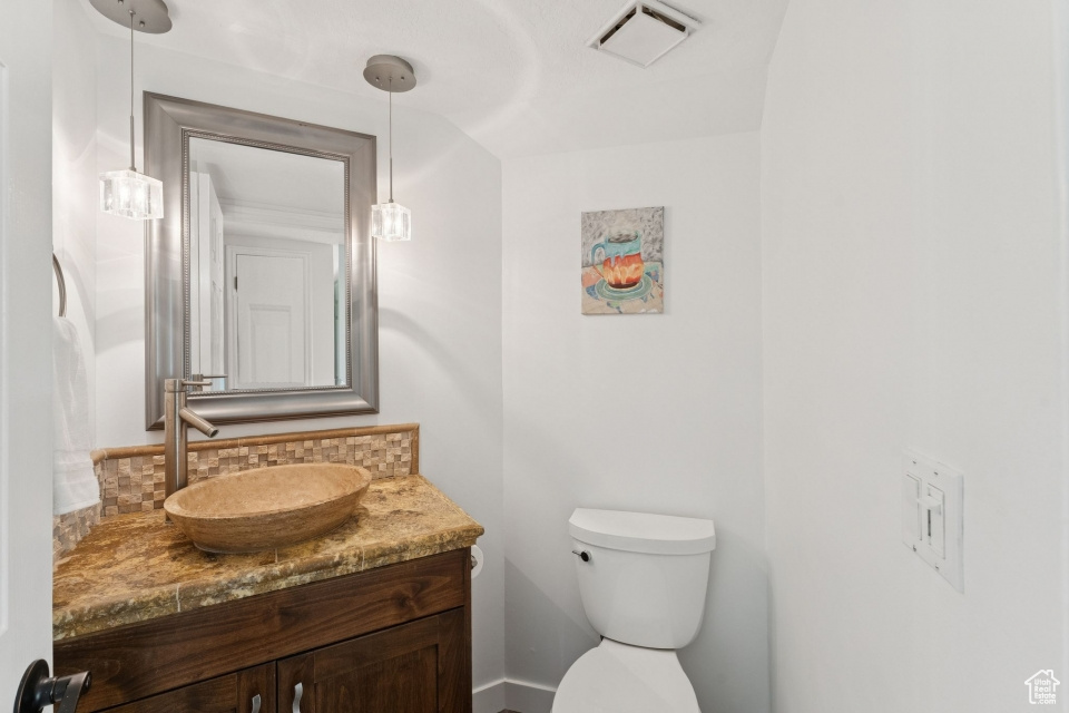 Bathroom featuring tasteful backsplash, vanity, and toilet