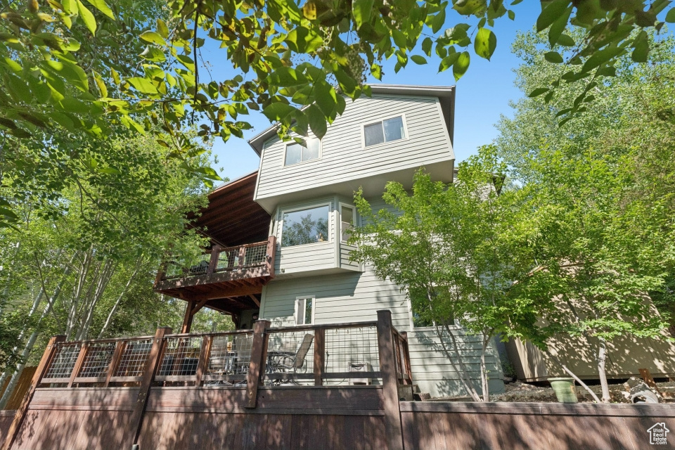 View of front of home featuring a balcony and a wooden deck