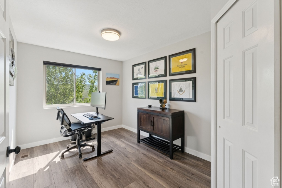 Office featuring dark wood-style flooring and baseboards