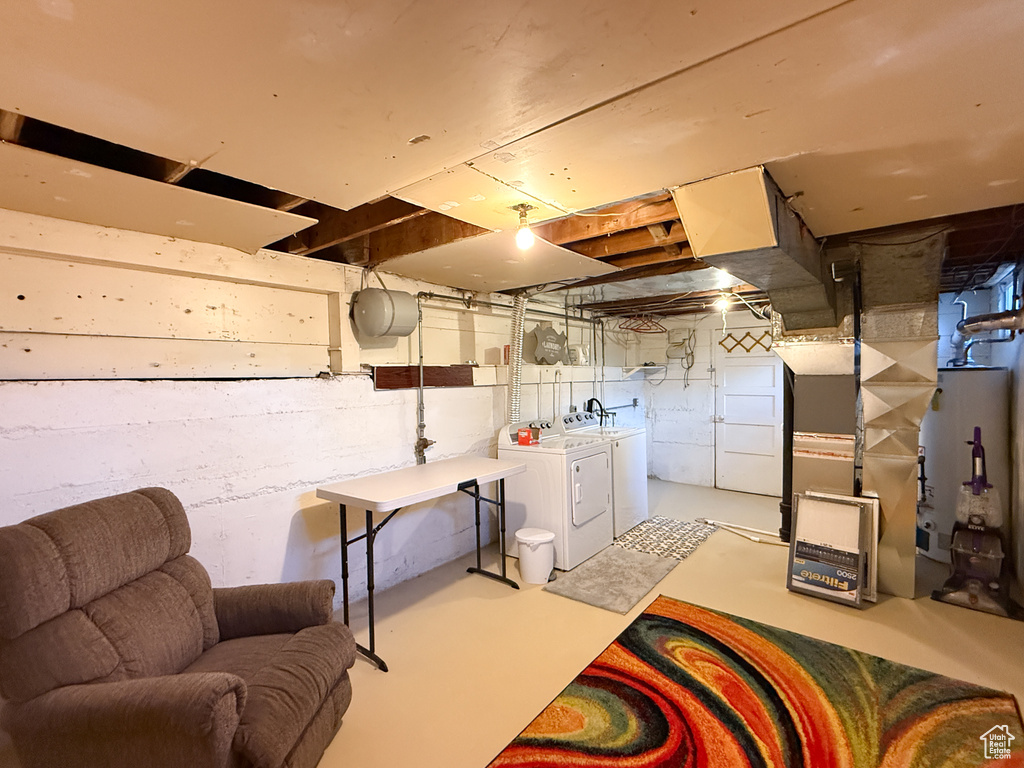 Unfinished below grade area with gas water heater, washing machine and dryer, and heating unit