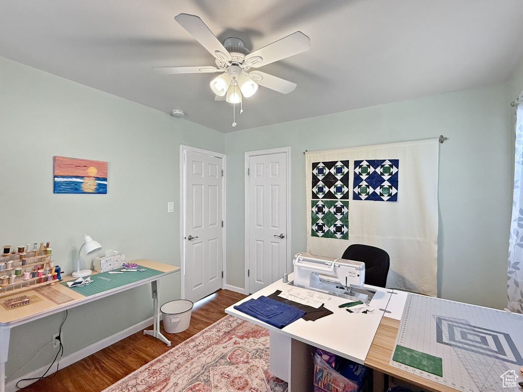 Office space with dark wood-style floors and ceiling fan