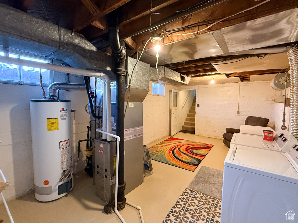 Basement with water heater, washer and dryer, stairs, and heating unit