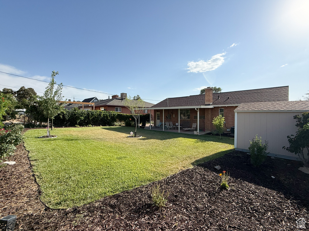 View of green lawn with a patio