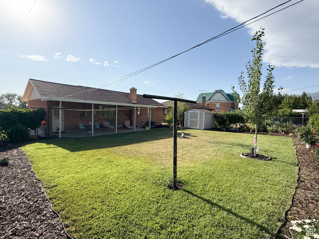 View of yard with a storage unit and a patio