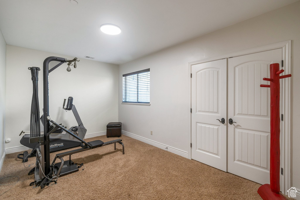 Exercise room with carpet floors and baseboards