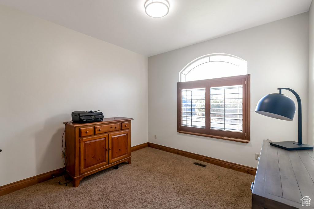Home office featuring light carpet and baseboards