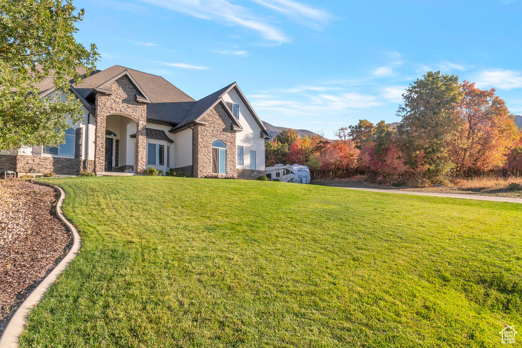 View of home\'s exterior featuring stone siding and a lawn