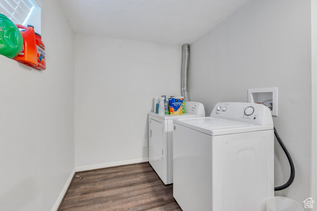 Laundry area featuring washing machine and clothes dryer, dark wood-style flooring, and baseboards