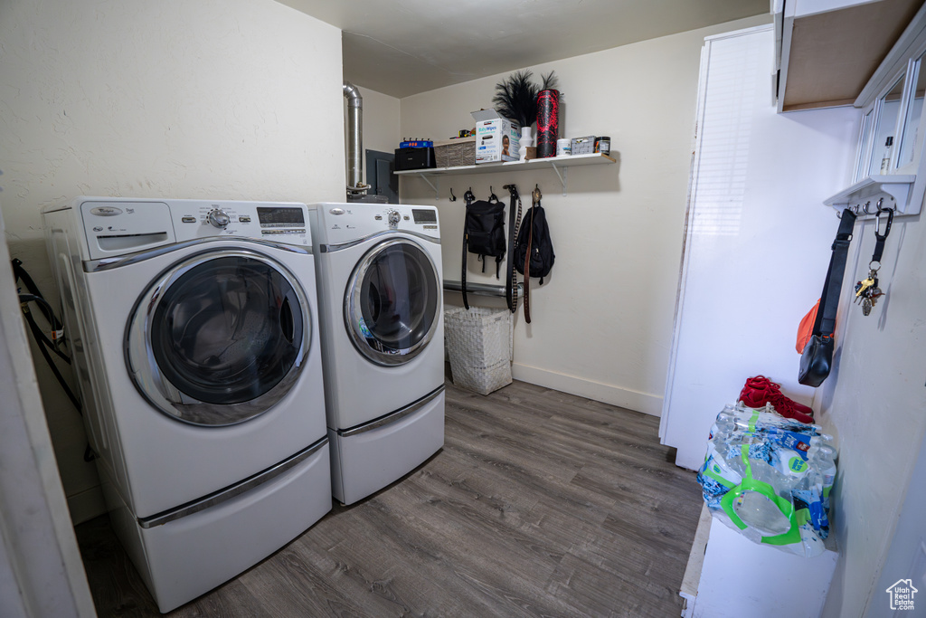 Washroom with separate washer and dryer, dark wood-type flooring, baseboards, and cabinet space