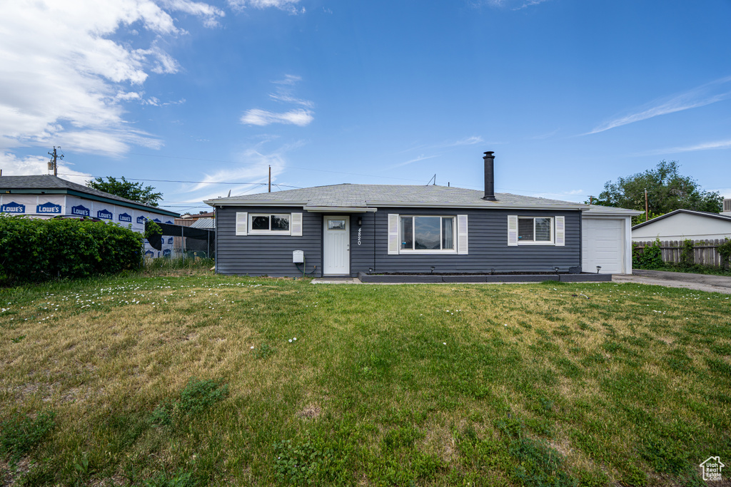 View of front of home with an attached garage and asphalt driveway