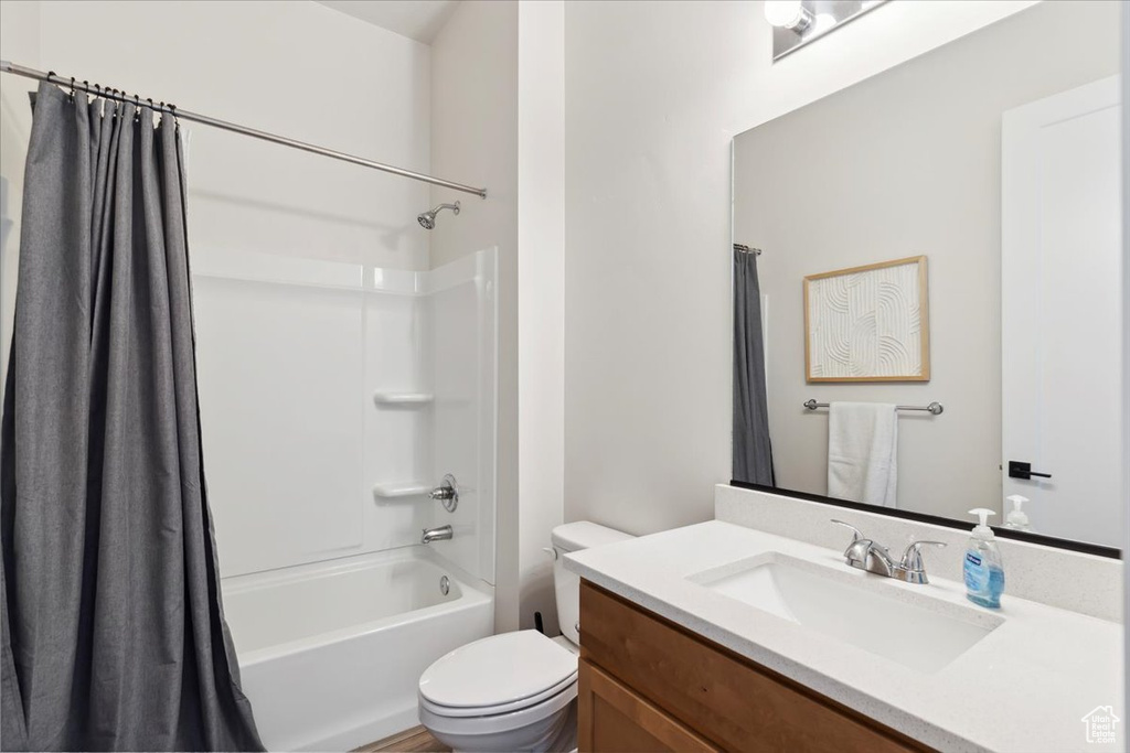 Bathroom with vanity, toilet, and shower / bath combo with shower curtain